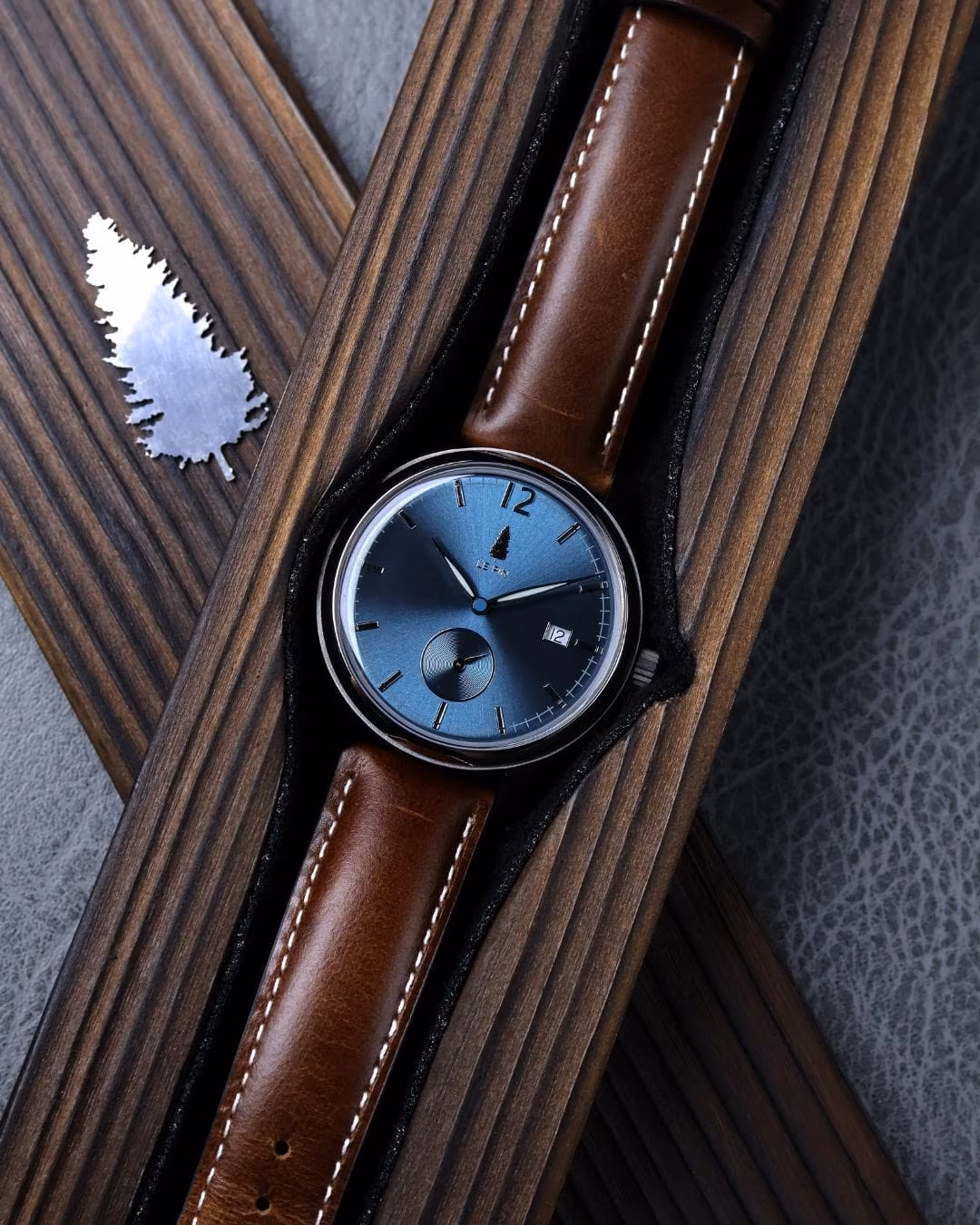 The watch across dark ribbed wood, strap extended.